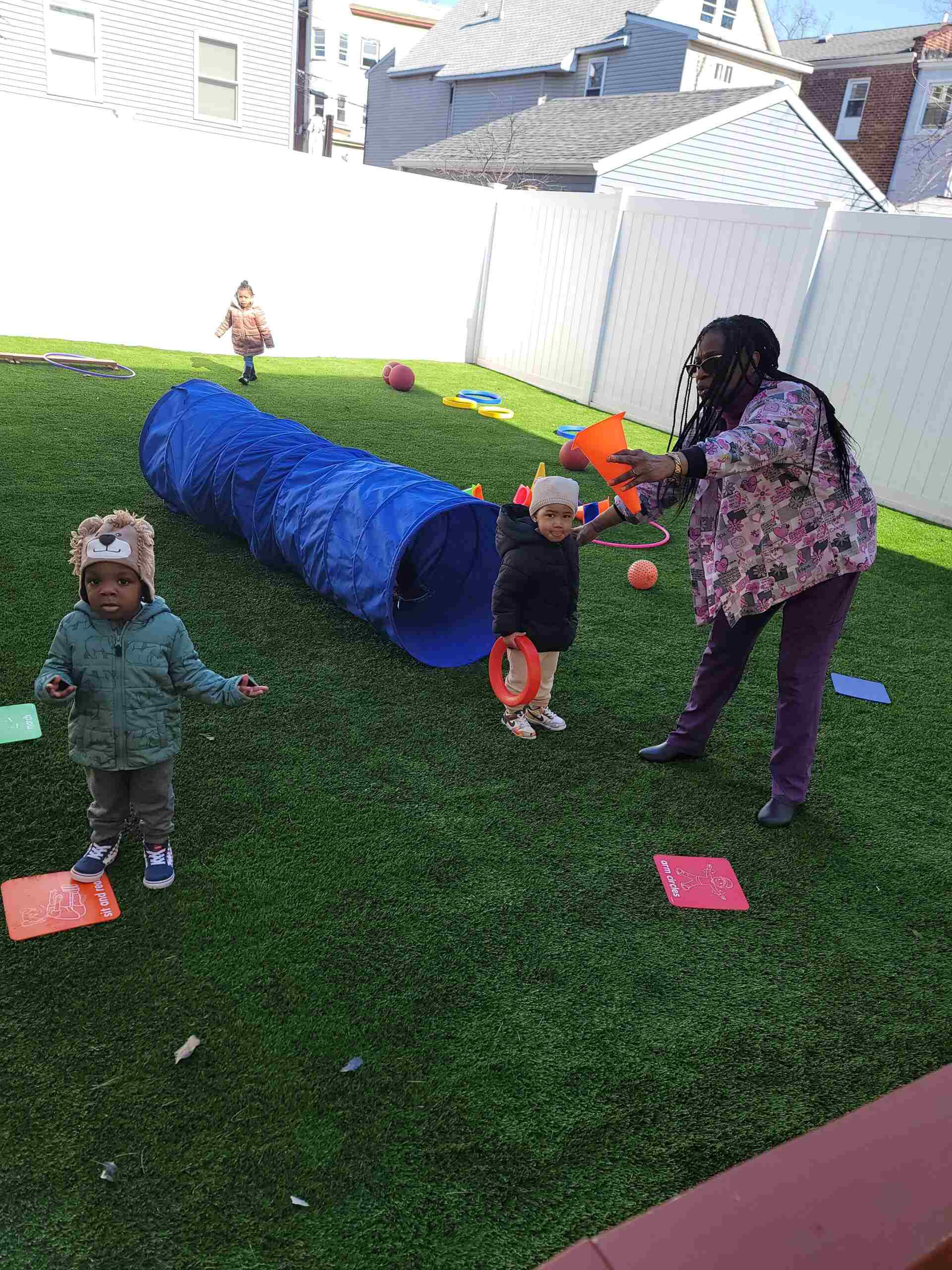 A lady playing with so many small children