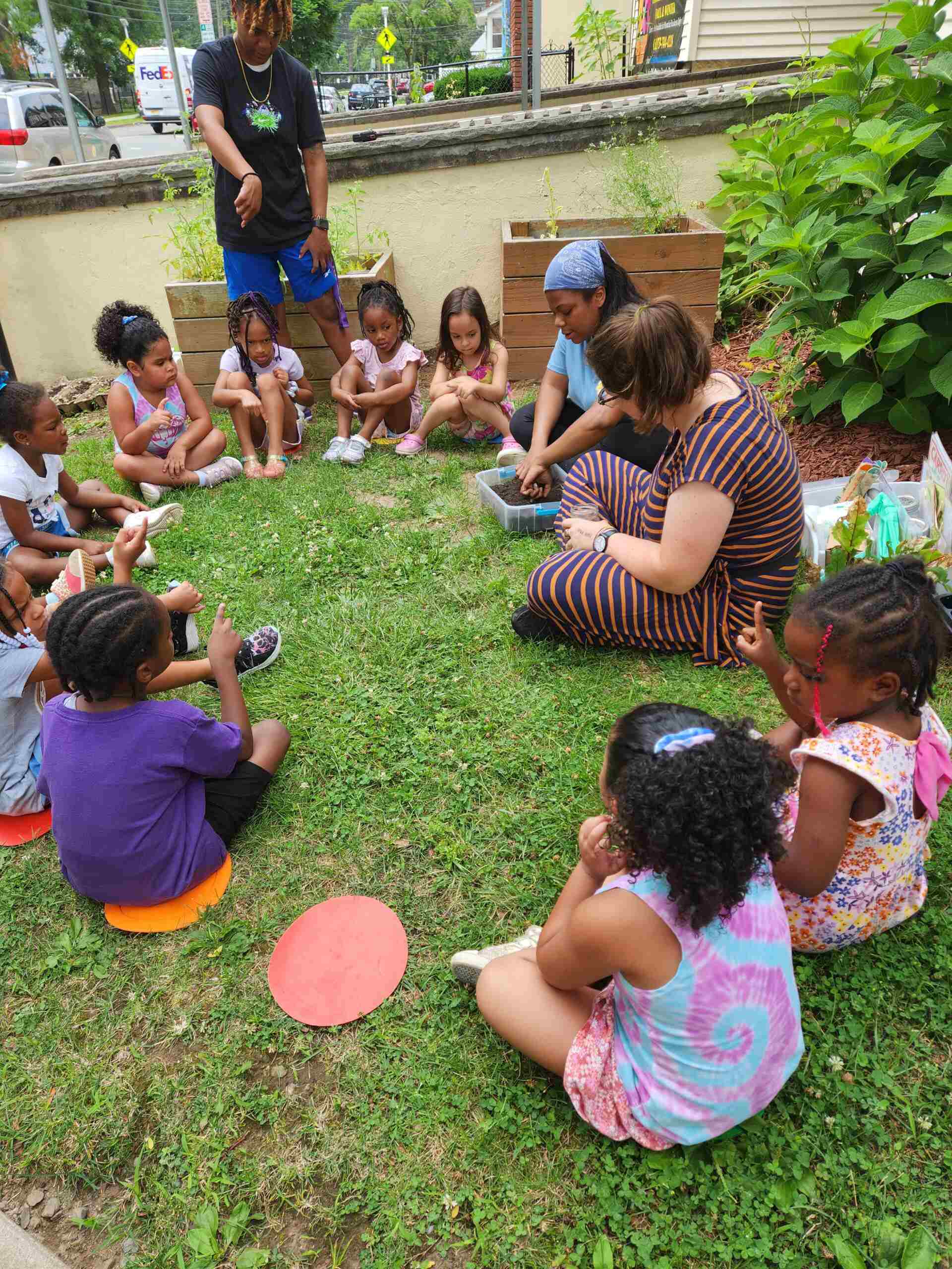 People sitting with small children at in a field