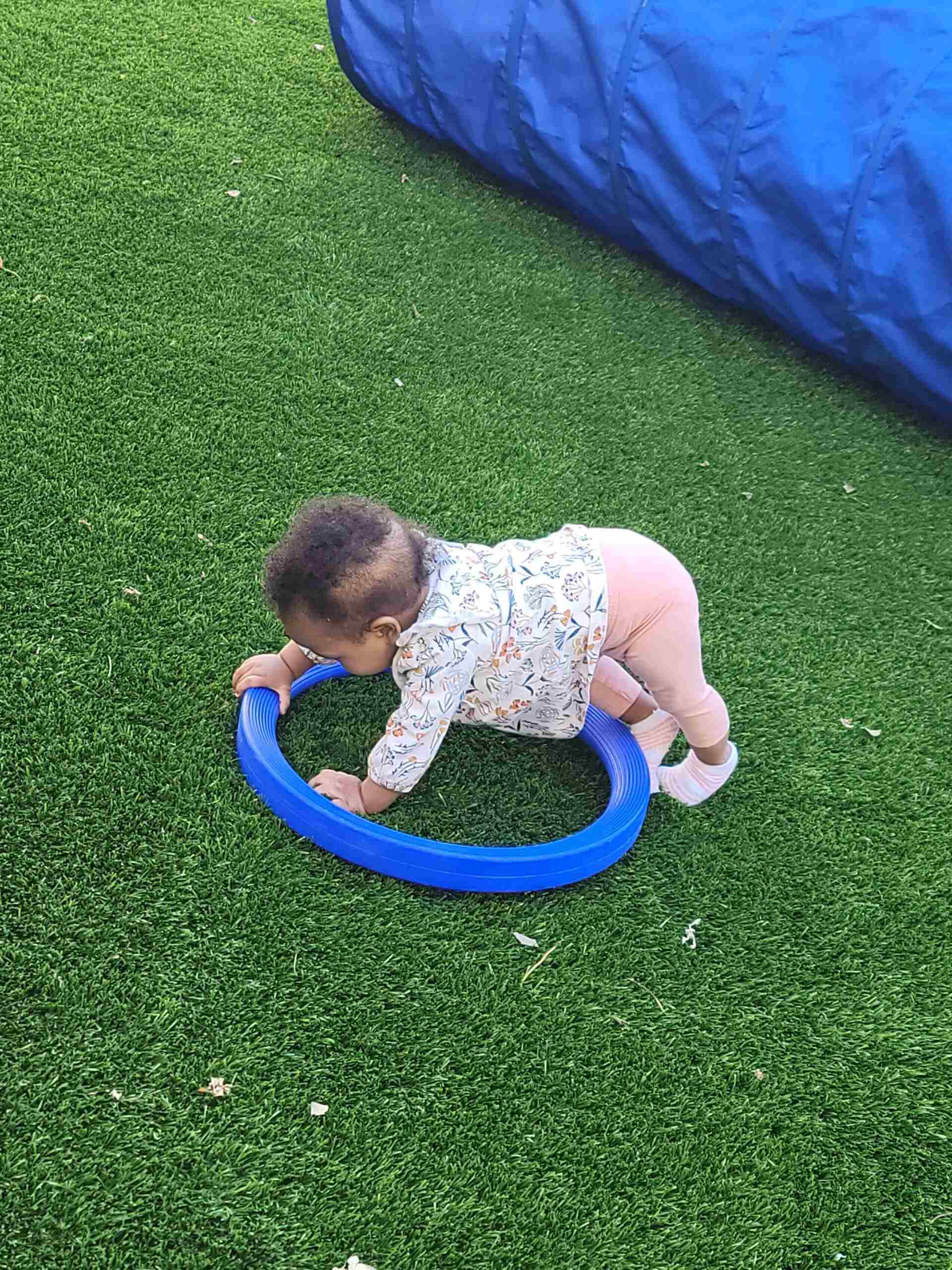 A small child playing with a ring in a field